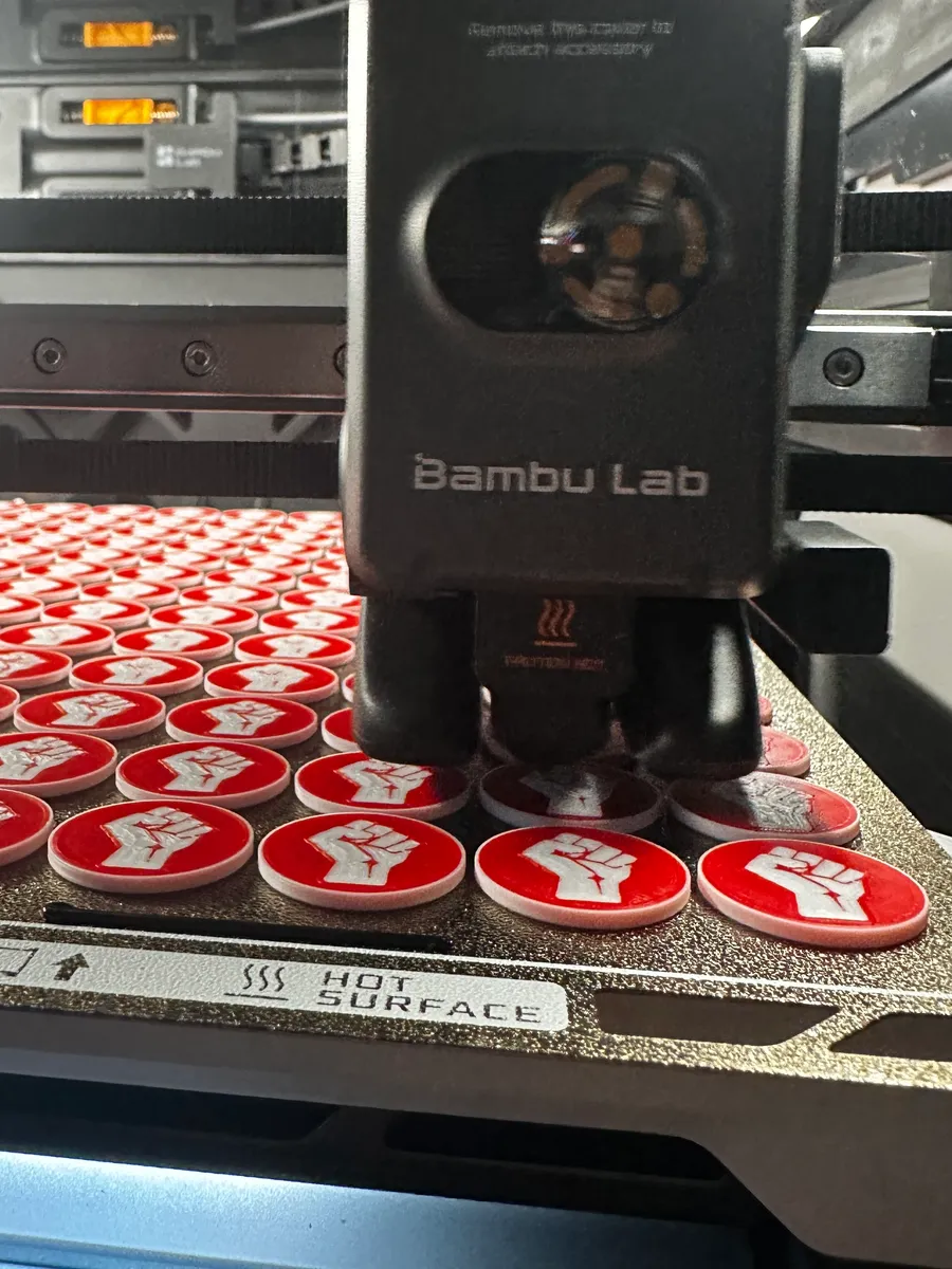Druckkopf eines Bambu Lab H2S über einem Druckbett voller mehrfarbig gedruckter Einkaufswagenchips