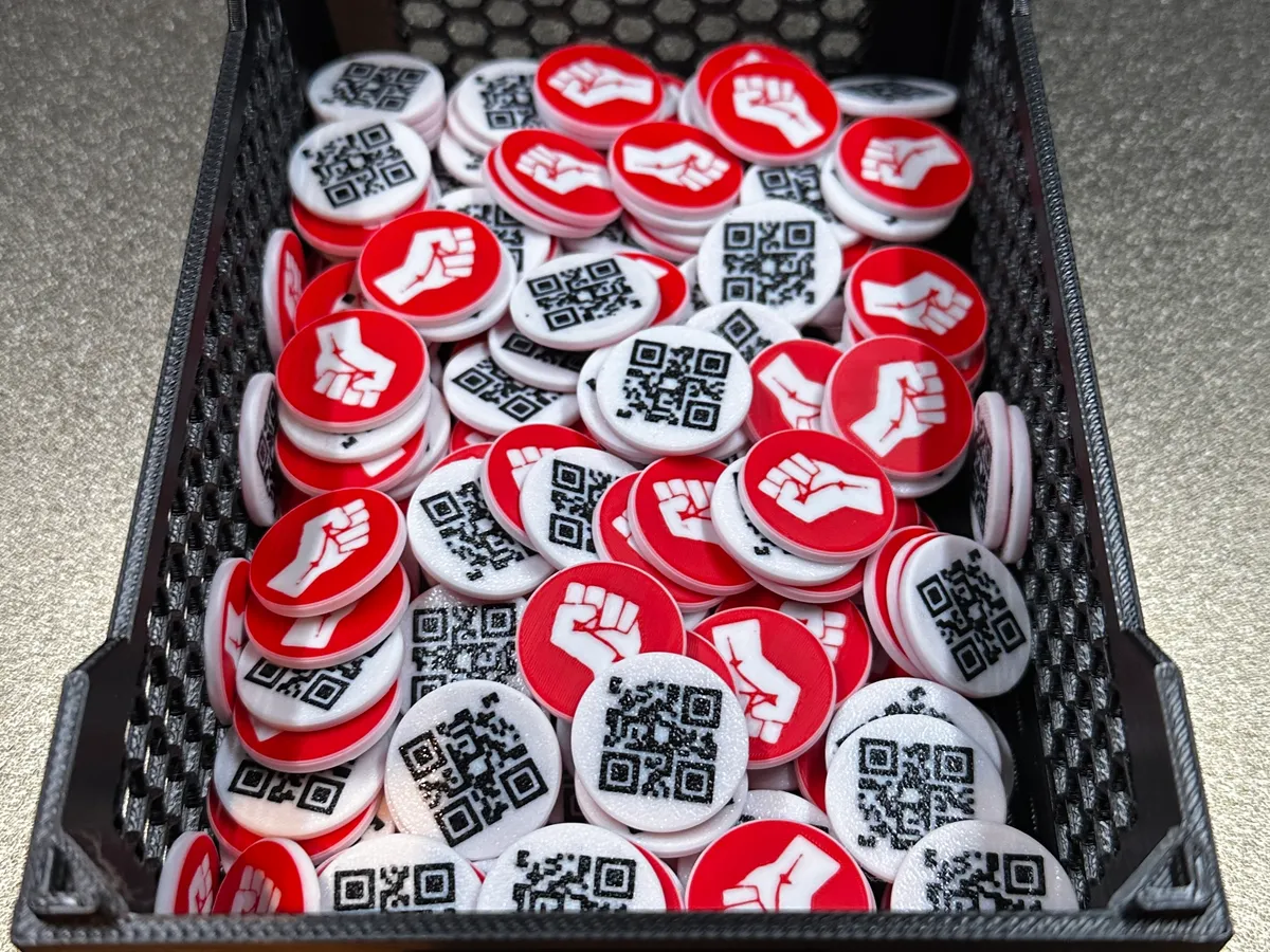 Kiste voller fertig gedruckter Einkaufswagenchips mit Faust-Motiv, bereit für den Versand